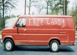This is a picture of a creepy van with the words "Free Candy" spray painted on the side.