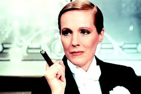 This is a photo of Julie Andrews in a tuxedo, smoking a cigar.