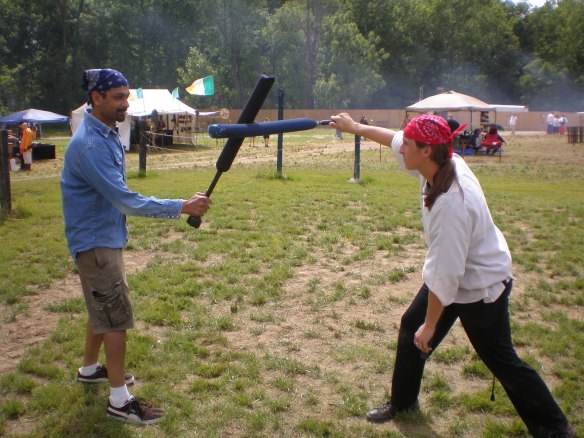 This is an image of two men sparring with foam weapons and dressed as hillbillies